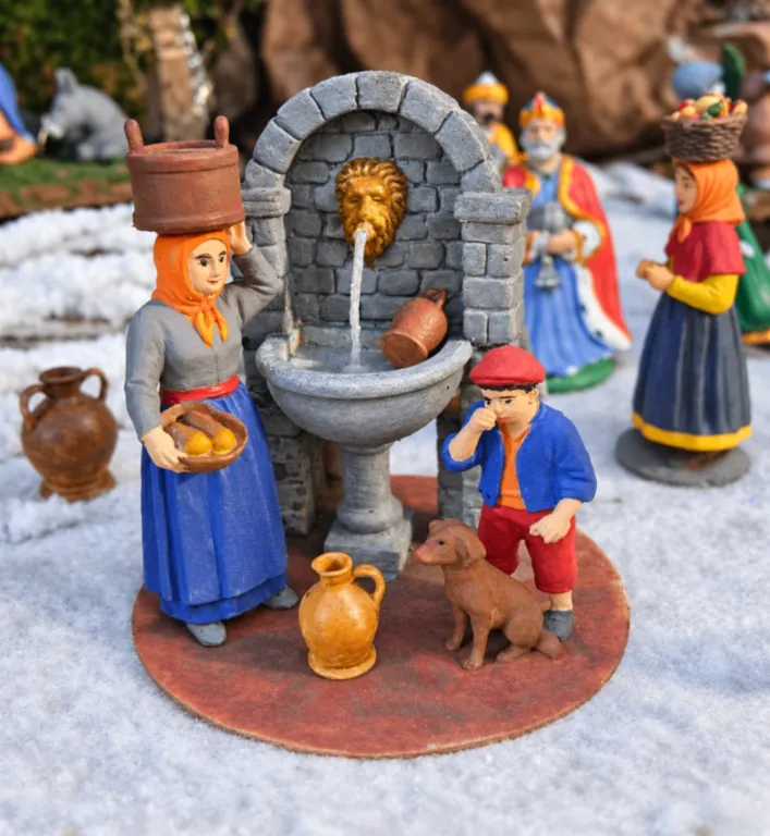 Scène de fontaine pour crèche corse avec personnages, poteries et animal creche-corse-scene-fontaine-santons-village.webp