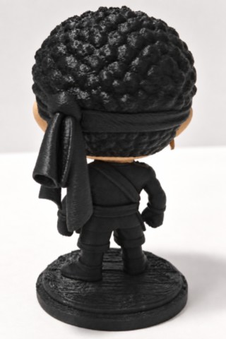 Vue de dos de la figurine corse 3D Moru montrant le bandeau noir noué derrière la tête et la tenue noire. moru-figurine-corse-3d-corsica-pop-vue-dos-fabbrica-corsa