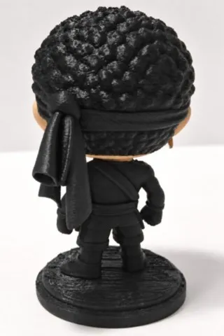 Vue de dos de la figurine corse 3D Moru montrant le bandeau noir noué derrière la tête et la tenue noire. moru-figurine-corse-3d-corsica-pop-vue-dos-fabbrica-corsa.webp