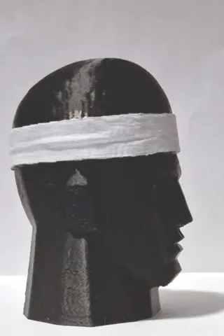 Petra Mora, tête noire stylisée avec bandeau blanc vue de profil droit petra-mora-figurine-corse-9cm-profil-droit.webp